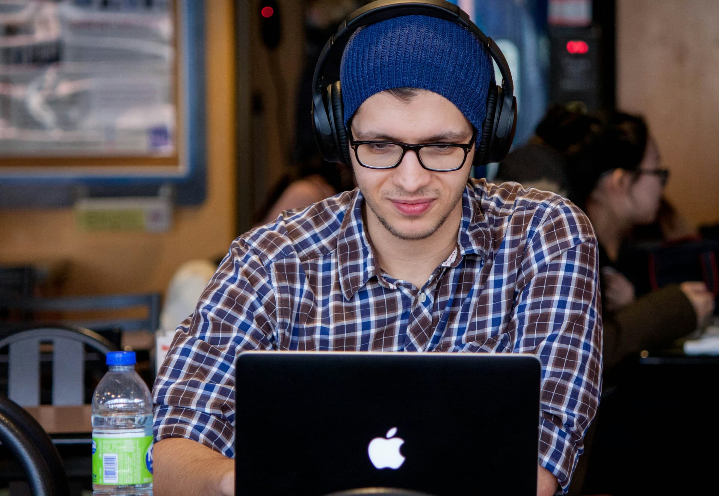 man with laptop in a bar - Shopify Custom Sections